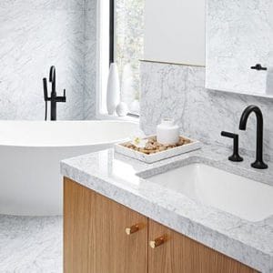 חדר רחצה עם משטחי שיש ואמבטיה.